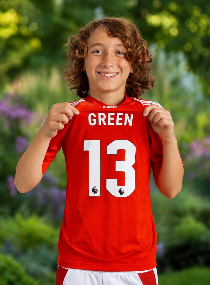 Daniel Green holding up his Green 13 soccer jersey